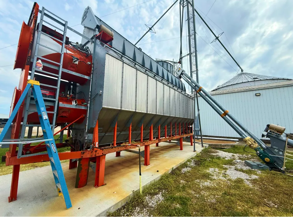 Grain dryer with access ladder and connected spouting.