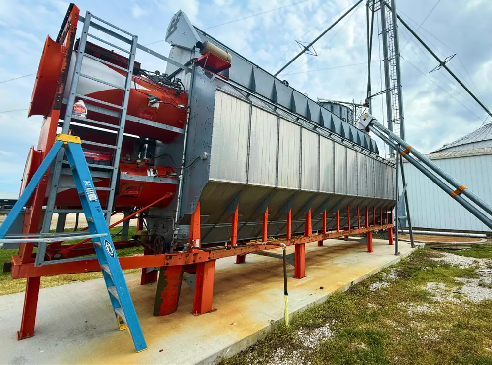 Grain dryer with access ladder and connected spouting.